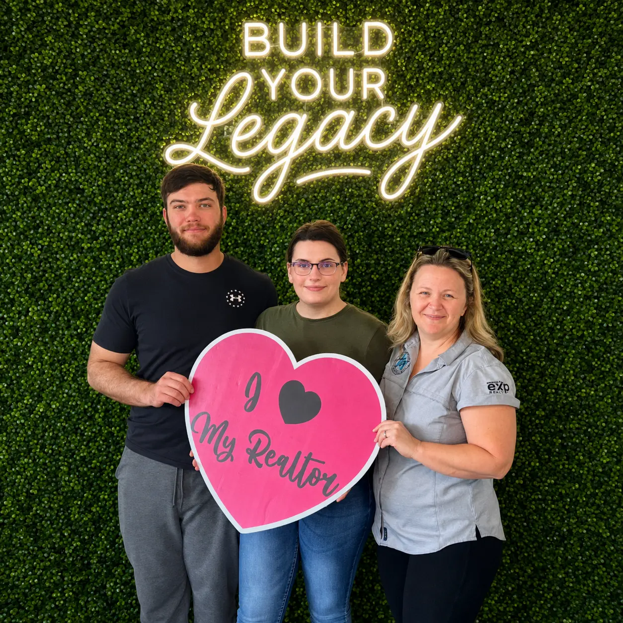 Clients holding an I Love My Realtor sign at Legacy Premier Title